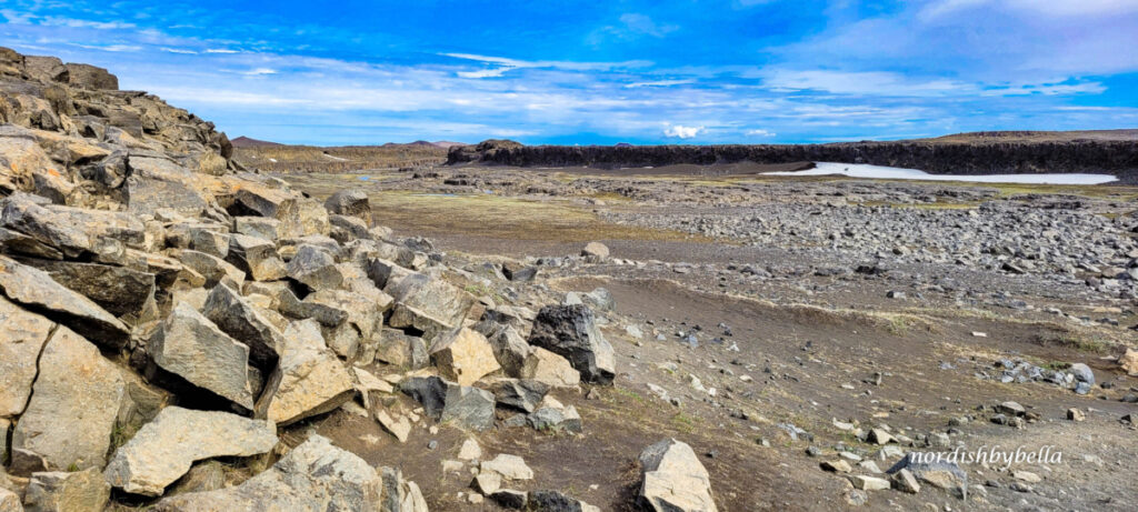 Steinlandschaft mit Schneefeld auf der Westseite des Wasserfalls Dettifoss