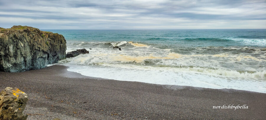 Dunkler Strand mit Meer