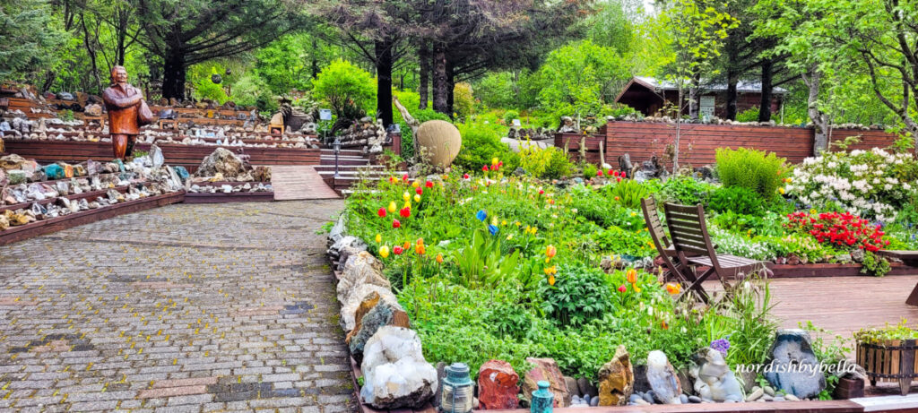 Blumenbeet und Holzstufen mit gesammelten Steinen