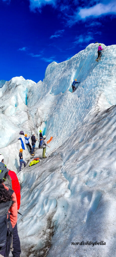 An einer Eiswand kletternde Menschen